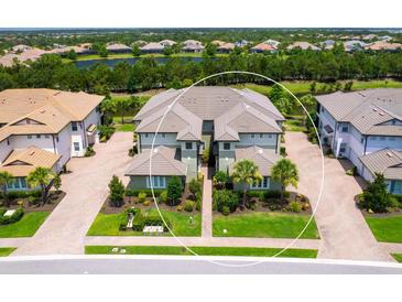 A beautiful aerial view of the condos featuring lush landscaping, lake views, and a well-maintained community at 7387 Divot Loop # 15-D, Lakewood Ranch, FL 34202