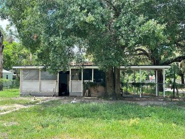 Charming single-story home featuring mature trees and a screened-in porch for outdoor enjoyment at 9344 Peony St, New Port Richey, FL 34654