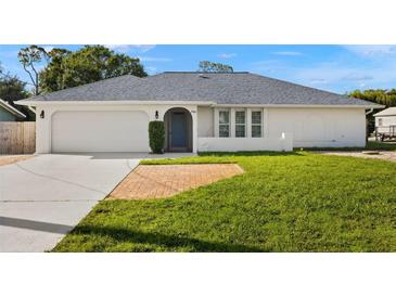 Charming single-story home featuring a well-maintained lawn and attached two-car garage at 19897 Midway Blvd, Port Charlotte, FL 33948