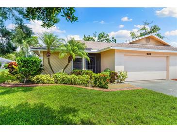 Charming single-story home featuring a well-manicured lawn and tropical landscaping with lovely curb appeal at 3530 Wilkinson Woods Dr # 14, Sarasota, FL 34231