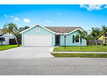 Charming aqua home with well-kept lawn, large driveway, and a two-car garage at 3551 65Th Avenue E Cir, Sarasota, FL 34243