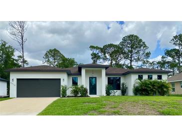 Stunning single-story home featuring a modern design, lush landscaping, and a spacious two-car garage at 3616 Bellefonte Ave, North Port, FL 34286