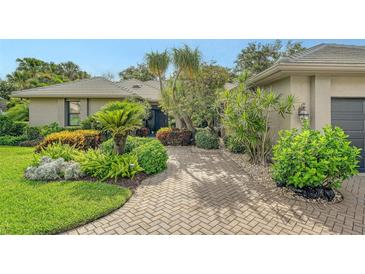 Charming home features a lush, landscaped front yard and a brick driveway at 4761 Pine Harrier Dr, Sarasota, FL 34231