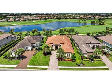 Stunning lakefront home with lush landscaping, tile roof and golf course views in a desirable community at 5104 Benito Ct, Bradenton, FL 34211