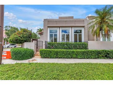 Charming home exterior featuring a well-manicured hedge and secure black metal fence, blending privacy with curb appeal at 200 Cocoanut Ave # 1, Sarasota, FL 34236