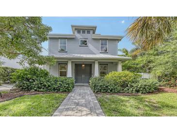 Charming two-story home features a well-manicured lawn and lush landscaping at 2410 Prospect St, Sarasota, FL 34239