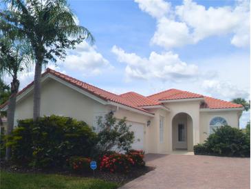 Charming single-story home with a red tile roof, brick driveway, arched entryway, and well-maintained landscaping at 5779 Wilena Pl, Sarasota, FL 34238