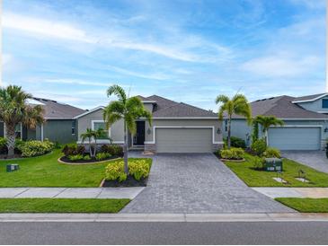 Charming single-story home featuring a well-manicured lawn and attractive paved driveway at 6550 Devesta Loop, Palmetto, FL 34221