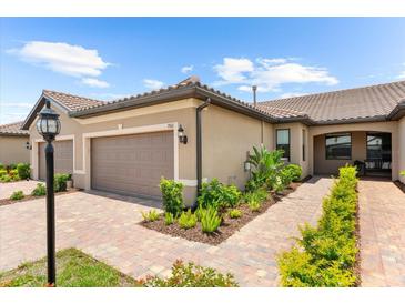 Charming home featuring well-maintained landscaping, a tile roof, and a two-car garage at 7661 Summerland Cv, Bradenton, FL 34202