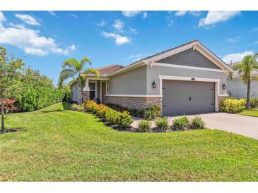Charming single-story home with manicured lawn, stone accents, and a two-car garage at 8641 Rain Song Rd, Sarasota, FL 34238