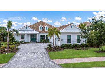 Inviting single-Gathering home boasting lush landscaping and a charming light-blue exterior at 16511 Cornwall Ln, Lakewood Ranch, FL 34202