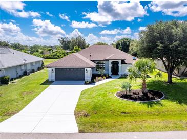 Beautiful single-story home with a well-manicured lawn, lush landscaping, and a freshly sealed driveway at 234 Antofagasta St, Punta Gorda, FL 33983