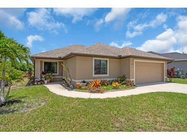 Charming single-story home with a well-manicured lawn and colorful landscaping at 529 Sunset N Rd, Rotonda West, FL 33947