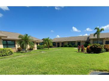 Well-maintained lawn and landscaping add to the curb appeal of this condo complex under a bright, sunny sky at 6132 29Th W Ave, Bradenton, FL 34209