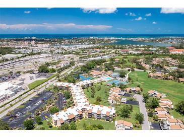 Beautiful aerial view of the community with lush landscaping, a pool, and ocean views at 618 Bird Bay S Dr # 113, Venice, FL 34285