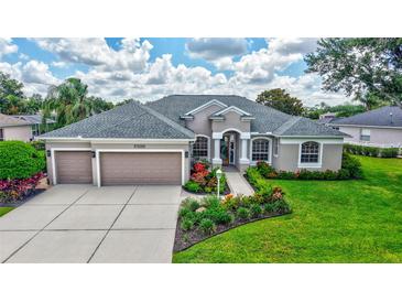 Beautiful single-story home with a three-car garage, manicured lawn, and colorful landscaping at 11250 Rivers Bluff Cir, Lakewood Ranch, FL 34202