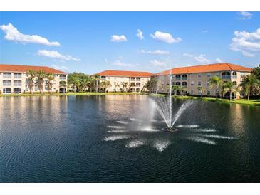 Scenic view of condo buildings surrounding a tranquil lake with a fountain under a blue sky at 150 L Pavia Blvd # 13, Venice, FL 34292