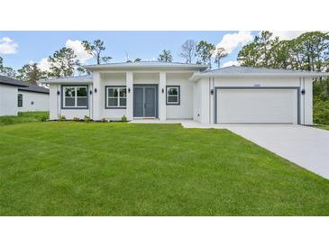 Beautiful new construction home with a well-manicured lawn and clean, modern architecture at 2523 Hagerick Ln, North Port, FL 34288