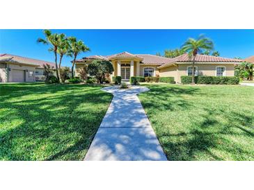 Inviting single-story home featuring lush landscaping, a tiled roof, and a walkway to the front entrance at 8315 Eagle Xing, Sarasota, FL 34241