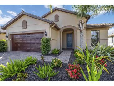 Inviting single-Gathering home featuring a well-manicured lawn and a charming exterior with a two-car garage at 11221 Sandhill Preserve Dr, Sarasota, FL 34238