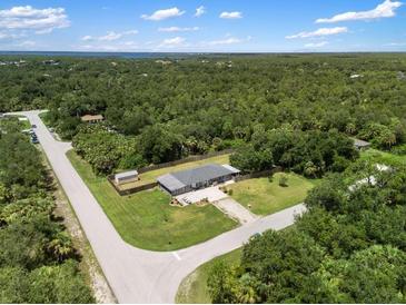Expansive aerial view of a well-maintained home surrounded by lush greenery at 17211 Drayton Ln, Port Charlotte, FL 33948