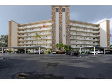 Condo building featuring balconies, covered parking, manicured landscaping, and a stone accent center at 3680 Ironwood Cir # 603L, Bradenton, FL 34209