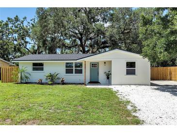 Charming single-story home with a freshly painted exterior, landscaping, and a welcoming teal front door at 4041 Linwood St, Sarasota, FL 34232