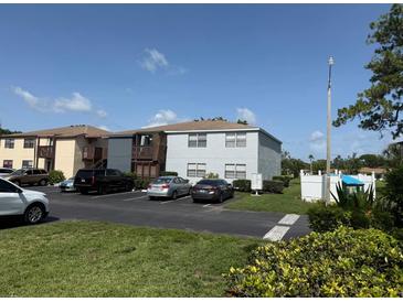 View of a two-story condominium building with parking, landscaping, and mailbox area under a sunny blue sky at 5026 Water Oak Dr # 114, Bradenton, FL 34207