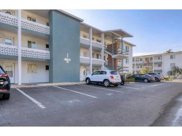 Low angle exterior of a condo building with parking spaces and second story apartments at 5891 Welcome Rd # I6, Bradenton, FL 34207
