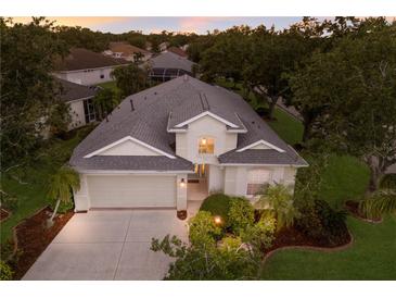 Inviting two-story home featuring a well-manicured lawn, a neutral stucco exterior, and a two-car garage at 1245 Millbrook Cir, Bradenton, FL 34212