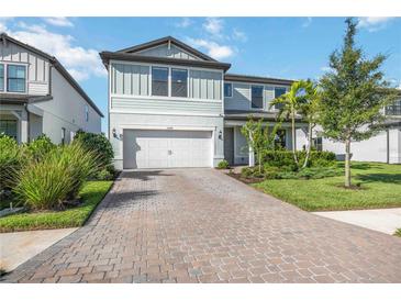 Charming two-story home with well-manicured landscaping and a brick-paved driveway at 16418 Slate Pl, Lakewood Ranch, FL 34211