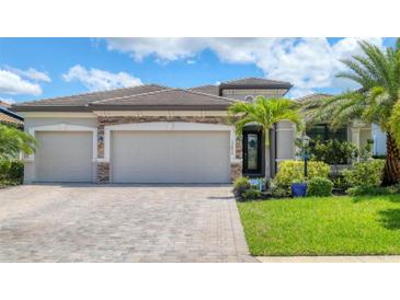 Well-maintained single-Gathering home with three-car garage, stone accents, and lush landscaping at 17850 Polo Trl, Bradenton, FL 34211
