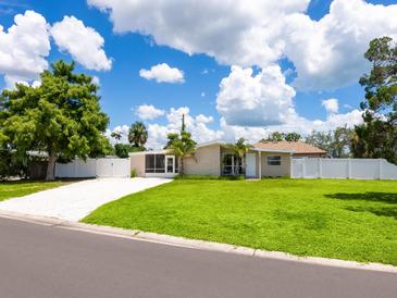 Charming home featuring a well-manicured lawn and a white picket fence at 2416 Emory Ave, Bradenton, FL 34207