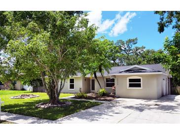 Charming single-story home featuring a well-manicured lawn, mature trees, and a cozy front exterior at 3236 Kingswood Dr, Sarasota, FL 34232