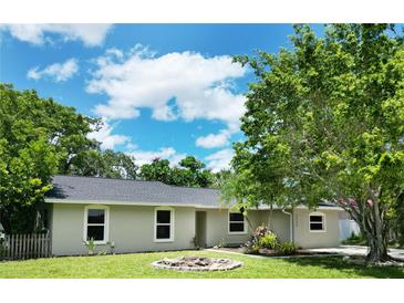 Charming single-story home with a well-manicured lawn, lush landscaping, and bright white window trim at 3236 Kingswood Dr, Sarasota, FL 34232