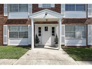Apartment entrance featuring a white door and columns with white shutters and potted plants at 4507 9Th W St # J11, Bradenton, FL 34207