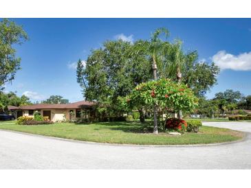 Charming single-story home with lush landscaping and mature trees on a sunny day at 6504 Heritage Ln # 99, Bradenton, FL 34209
