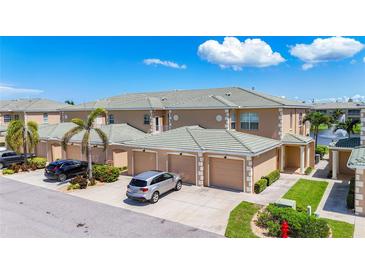 View of three attached townhomes with a shared driveway and tile roof on a sunny day at 6604 7Th Avenue W Cir, Bradenton, FL 34209