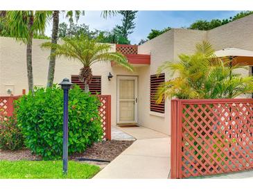 Charming courtyard entrance with lattice, palm trees, and a well-maintained walkway to the front door at 814 Spring Lakes Blvd # 14, Bradenton, FL 34210