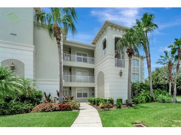 Elegant condo building with lush landscaping, balconies, and a charming walkway at 1000 San Lino Cir # 1034, Venice, FL 34292