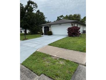 Charming one-story home with lush landscaping, a spacious driveway, and a two car garage at 1725 Briar Creek Ln, Sarasota, FL 34235