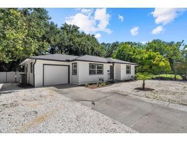 Charming single-story home featuring a well-maintained white exterior, a front yard, and a single car garage at 1857 Siesta Dr, Sarasota, FL 34239