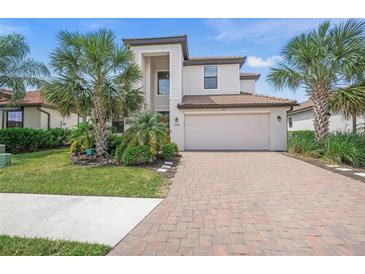 Beautiful two-story home featuring a brick driveway, attached garage, and well-manicured lawn with mature landscaping at 19369 Nearpoint Dr, Venice, FL 34292