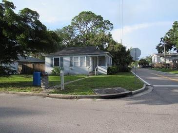 Charming single-story home with a cozy front porch, nestled on a tree-lined street corner lot at 2102 Arlington St, Sarasota, FL 34239