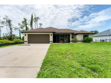 Inviting single-story home featuring a well-maintained lawn and a spacious two-car garage at 2237 Sadnet Ln, North Port, FL 34286