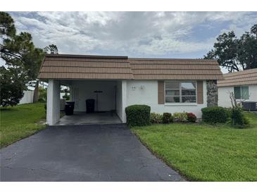 Charming single-story home with a covered carport, well-maintained lawn, and tidy landscaping at 2617 Riverbluff Pkwy # V151, Sarasota, FL 34231