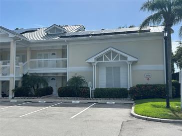 Condo exterior showcases a two-story facade, white railings, lush landscaping, and convenient parking at 3401 54Th W Dr # 201, Bradenton, FL 34210