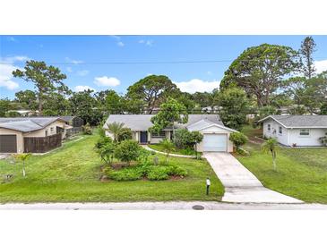 Charming single-story home with an attached garage, complemented by a lush, landscaped front yard and a cozy walkway to the front door at 408 67Th W Ave, Bradenton, FL 34207