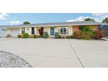Charming single-story home with blue entry door, well maintained landscaping, and large driveway at 6002 34Th W Ave, Bradenton, FL 34209