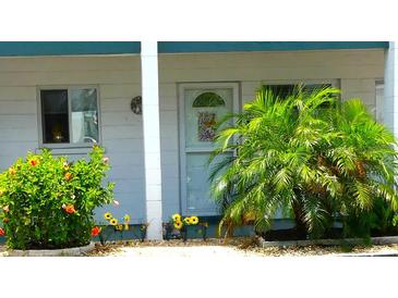 Inviting front door entrance with colorful landscaping and a welcoming aesthetic at 1850 Sunny Dr # F4, Bradenton, FL 34207